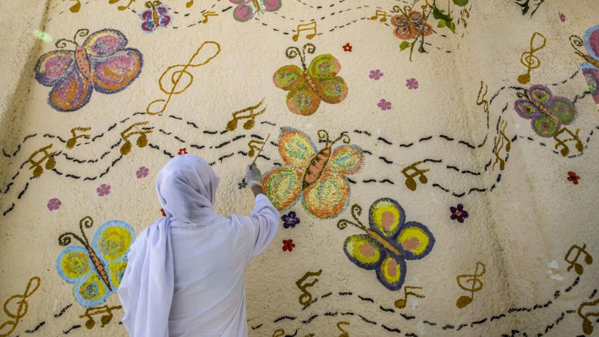 This picture taken during a government-guided tour on December 27, 2020 shows an inmate drawing a mural on a wall at al-Qanatir women's prison, at the tip of the Nile delta in Qalyoubiya province, about 30 kilometres north of Egypt's capital. Khaled DESOUKI / AFP