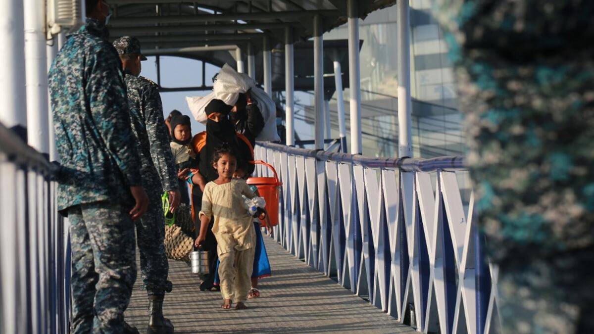 Rohingya refugees embark on a Bangladesh Navy ship as they are relocated to the controversial flood-prone island Bhashan Char in the Bay of Bengal, in Chittagong on December 29, 2020. Rehman ASAD / AFP