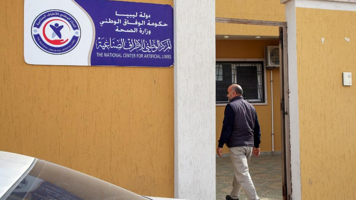 Libyan fishmonger Radwan Jibril enters the National Center for Artificial Limbs for a consultation, in the port city of Misrata, on December 17, 2020. With Libya's health sector left in tatters by its multiple conflicts since the 2011 revolution, war-wounded Libyans are often sent abroad for treatment, at the expense of the state. MAHMUD TURKIA / AFP