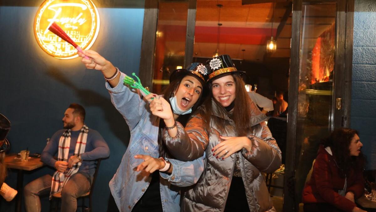 People share a drink to celebrate New Year's eve at a pub in the capital Beirut on January 1, 2021. ANWAR AMRO / AFP
