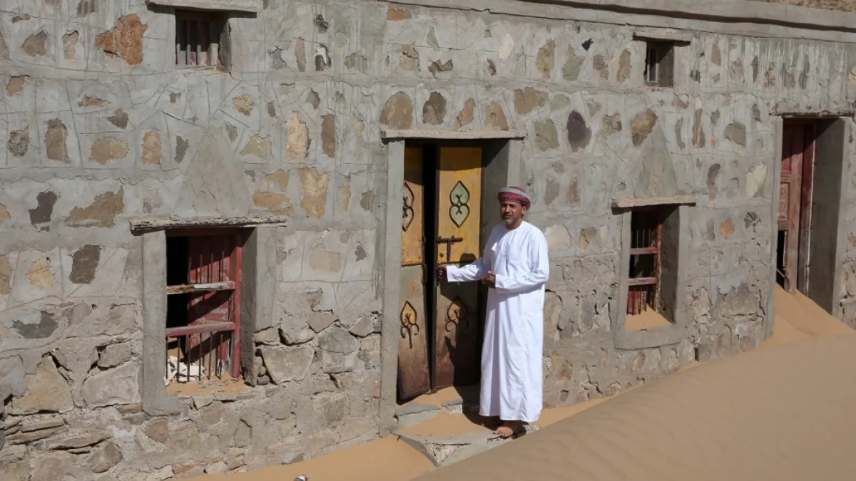 Mohammed al-Ghanbousi, a former inhabitant of Wadi al-Murr, stands next to his abandoned house in the Omani village, about 400 kms (250 miles) southwest of the capital Muscat, on December 31, 2020. Encroaching desert sands have left little evidence that Wadi al-Murr ever existed, but former inhabitants, while resigned to its destruction, are trying to preserve its memory. MOHAMMED MAHJOUB / AFP