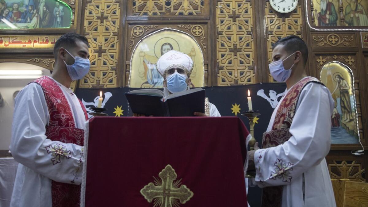An Egyptian Coptic priest (C) holds Christmas Eve mass at the Coptic Catholic St. Mark Church in Minya city, some 245 kilometres south of the capital Cairo on January 6, 2021.   Roger ANIS / AFP