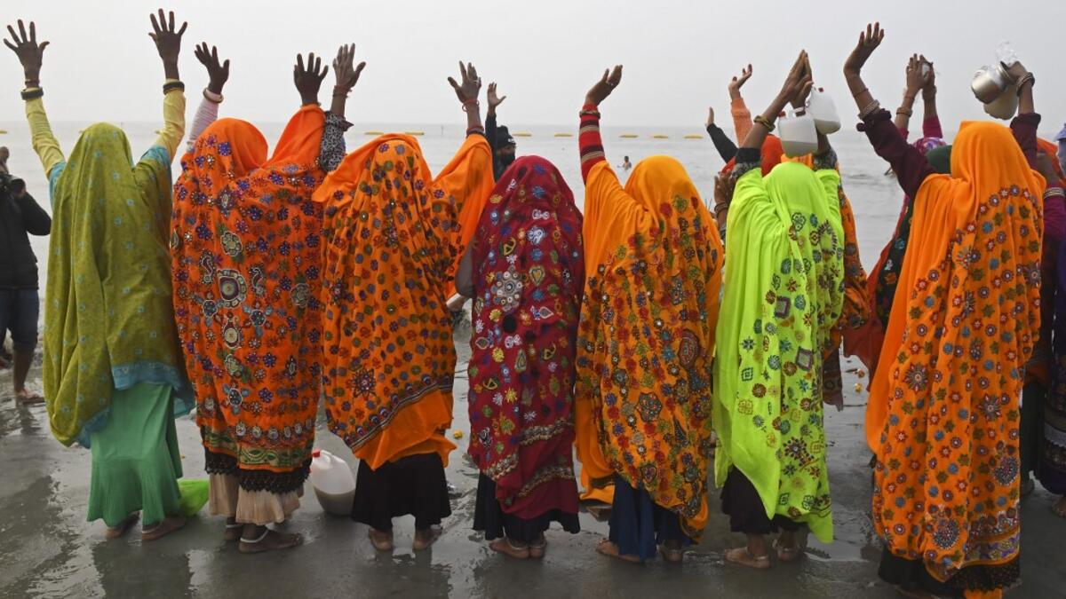 Hindu pilgrims pray after taking a holy dip at the confluence of Ganges and the Bay of Bengal during the Gangasagar Mela on the occasion of Makar Sankranti, a day considered to be of great religious significance in Hindu mythology, at Sagar Island, around 150 kms south of Kolkata on January 14, 2021. Dibyangshu SARKAR / AFP
