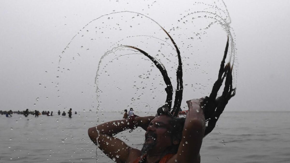 A Sadhu or a Hindu holyman takes a dip at the confluence of Ganges and the Bay of Bengal during the Gangasagar Mela on the occasion of Makar Sankranti, a day considered to be of great religious significance in Hindu mythology, at Sagar Island, around 150 kms south of Kolkata on January 14, 2021. Dibyangshu SARKAR / AFP