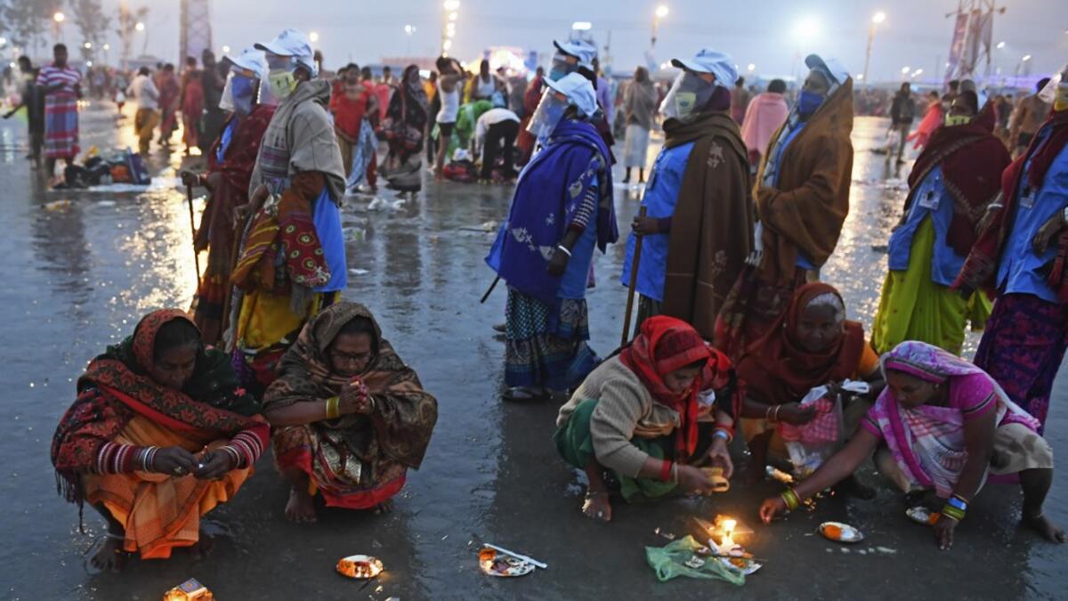 Members of local village panchayat wearing face shields and masks inspect the sanitization on the beach as a preventive measure against the Covid-19 coronavirus as Hindu pilgrims perform rituals at the confluence of Ganges and the Bay of Bengal during the Gangasagar Mela on the occasion of Makar Sankranti, a day considered to be of great religious significance in Hindu mythology, at Sagar Island, around 150 kms south of Kolkata on January 14, 2021. Dibyangshu SARKAR / AFP