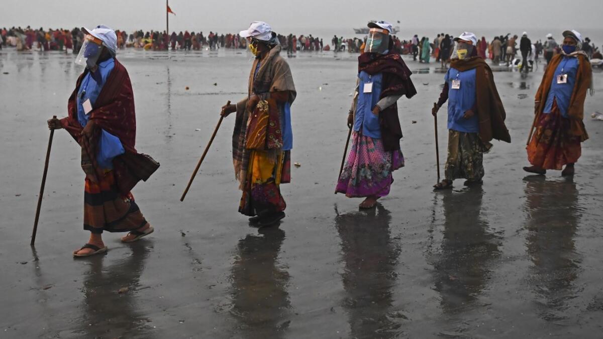 Members of local village panchayat wearing face shields and masks inspect the sanitization on the beach as a preventive measure against the Covid-19 coronavirus at the confluence of Ganges and the Bay of Bengal during the Gangasagar Mela on the occasion of Makar Sankranti, a day considered to be of great religious significance in Hindu mythology, at Sagar Island, around 150 kms south of Kolkata on January 14, 2021. Dibyangshu SARKAR / AFP