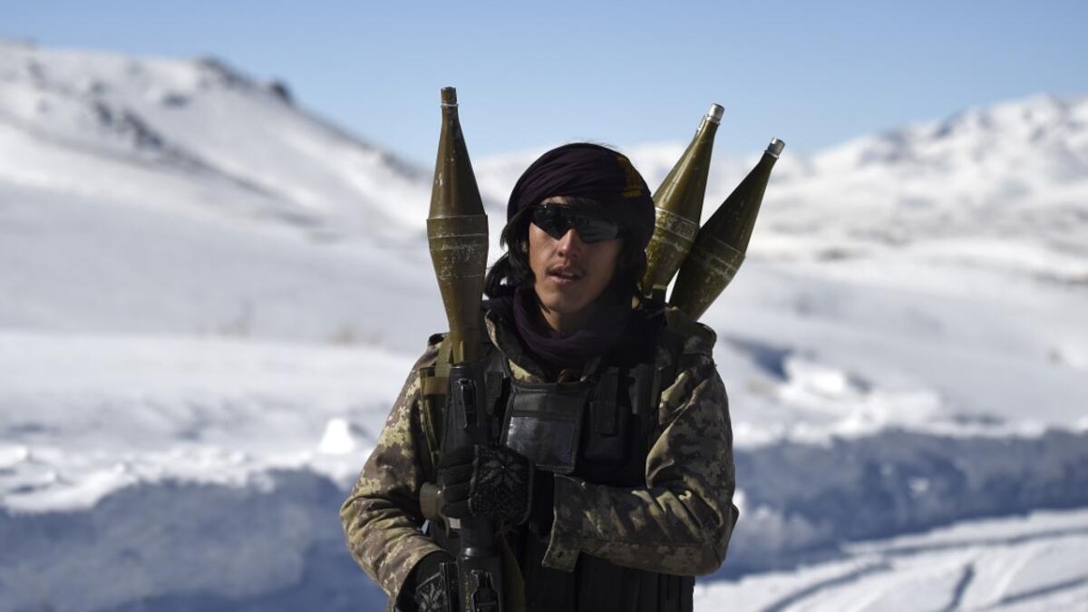 In this photo taken on January 9, 2021, a Hazara armed militia for the Resistance for Justice Movement, holds a rocket-propelled grenade (RPG) as he walks along a road during a patrol against Taliban insurgents at Hisa-e-Awali Behsud district of Maidan Wardak Province. Comprising roughly 10 to 20 percent of Afghanistan's 38-million population, Hazaras have long been persecuted for their largely Shiite faith by Sunni hardliners in a country wracked by deep ethnic divisions. WAKIL KOHSAR / AFP