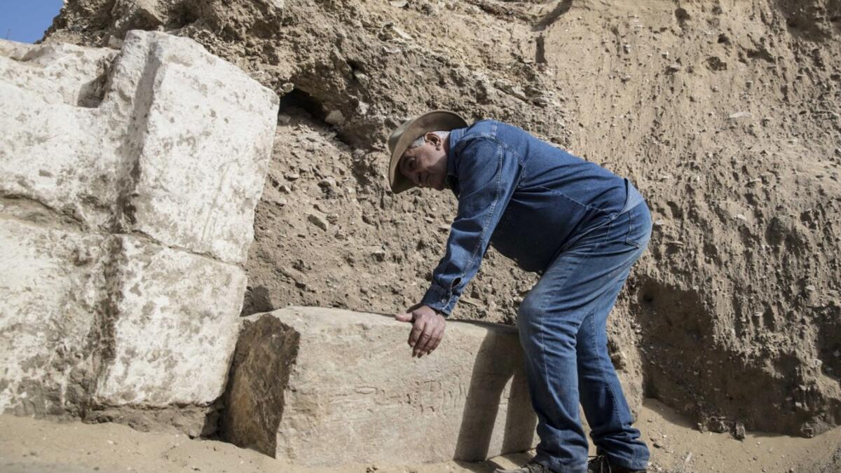 Egyptologist Zahi Hawass examines inscriptions on an unearthed structure during the official announcement of the discovery by an archaeological mission he leads of a new trove of treasures at Egypt's Saqqara necropolis south of Cairo, on January 17, 2021. The discovery at the necropolis which lies 30kms south of the Egyptian capital, includes the funerary temple of Queen Naert, wife of King Teti, as well as burial shafts, coffins, and mummies dating back to nearly 3000 years ago during the New Kingdom. Khal