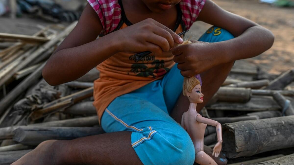 This photo taken on January 11, 2021 shows a Chin child playing with a doll in Bethel village in Hmawbi, on the outskirts of Yangon, where hundreds of members of the Chin ethnic community have settled after being displaced by fighting between Myanmar's military and the Arakan Army in the country's north.  Ye Aung THU / AFP