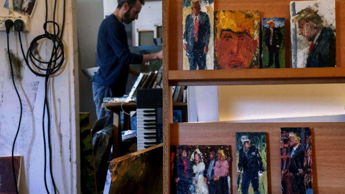 Israeli painter Iddo Markus works at his studio where he displays some of his paintings of former US president Donald Trump, in the northern port city of Haifa, on January 22, 2021. Markus became fascinated by the "tragic figure" of Donald Trump, and the walls and floor of his studio are packed with some 120 portraits of the former US presidents. Emmanuel DUNAND / AFP