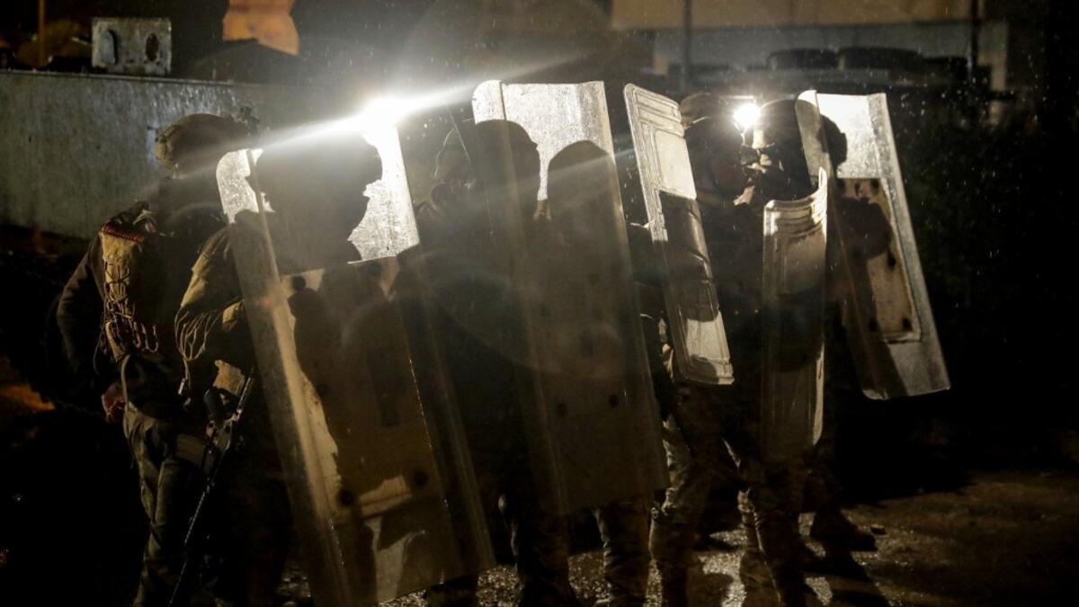 Lebanese security forces advance during clashes with anti-government protesters in the northern city of Tripoli, on January 29, 2021. More than 400 people have been wounded in northern Lebanon this week in clashes between security forces and protesters angered by a coronavirus lockdown they say is starving them. JOSEPH EID / AFP
