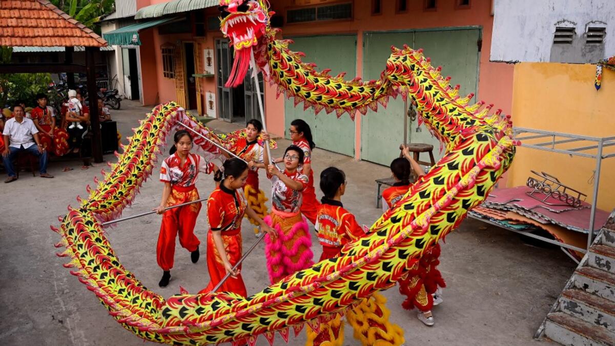 This photograph taken on January 20, 2021 shows Le Yen Quyen (C) practising a dragon dance routine along with other female dancers at the Tu Anh Duong lion and dragon dance school in Can Tho city in southern Vietnam's Mekong Delta. Manan VATSYAYANA / AFP