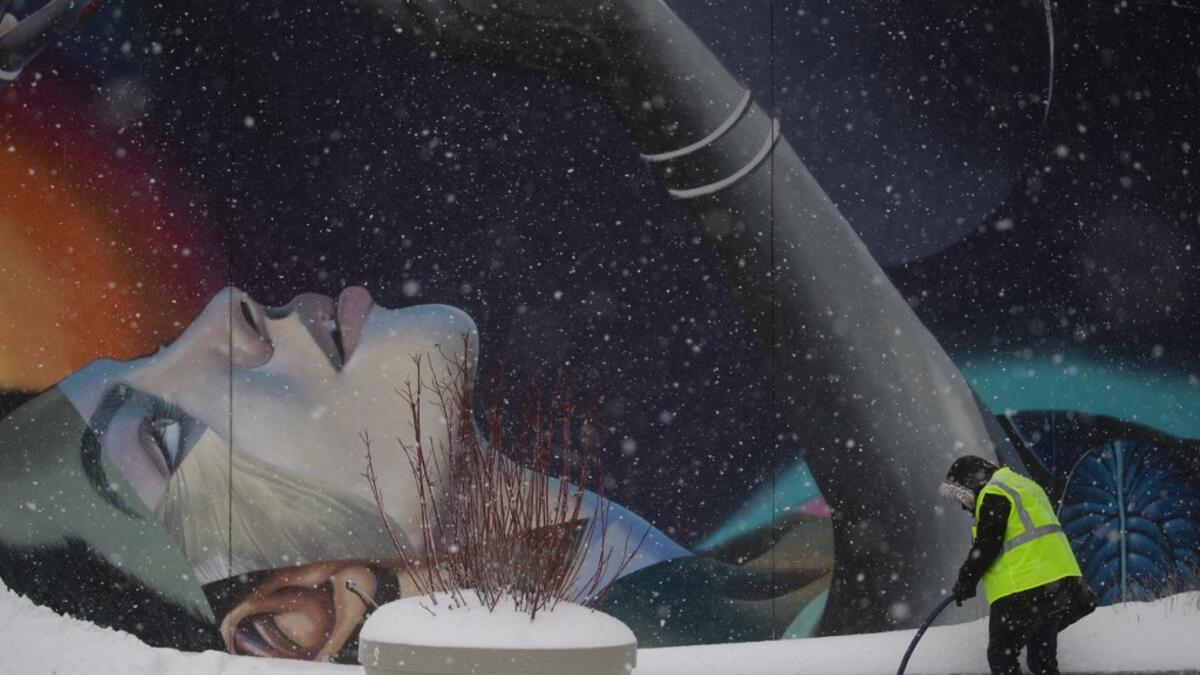 A worker cleans the stairs outside The Vessel in Hudson Yards during a winter storm on February 1, 2021 in New York City. A powerful winter storm is set to dump feet of snow along a stretch of the US east coast including New York City on February 1, 2021, after blanketing the nation's capital. The National Weather Service issued storm warnings from Virginia to Maine -- a swathe home to tens of millions of people -- and forecast snowfall of 18 to 24 inches (45-60 centimeters) in southern New York, northeaste