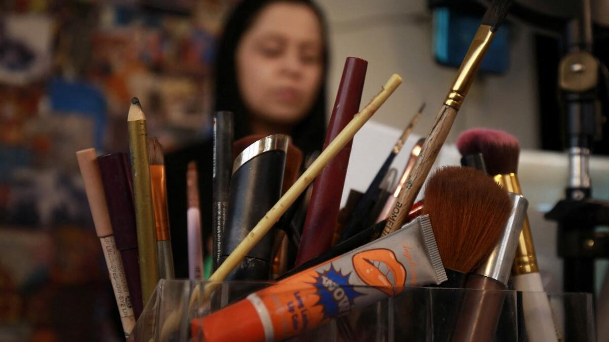 Jordanian make-up artist Alaa Bliha, 27, is pictured in front of her crayons and brushes, in the basement apartment where she lives with her mother and young brother in the capital Amman, on February 2, 2021. Bliha has beaten the lockdown blues and shot to online fame with videos of herself imitating famous figures from across the Arab world and beyond. From Donald Trump and Queen Elizabeth II to Egyptian superstars like singer Umm Kalthum and actor Adel Imam, her characters have made Alaa Bliha a star in h
