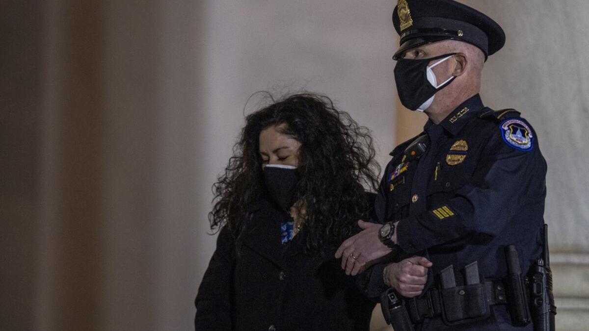 The family of late US Capitol Police officer Brian Sicknick, watch as his remains are carried up the steps of the Capitol in Washington, DC February 2, 2021. US President Joe Biden paid his respects Tuesday at a solemn memorial to the policeman killed last month during an attack on the Capitol by Donald Trump's supporters.  Tasos Katopodis / POOL / AFP