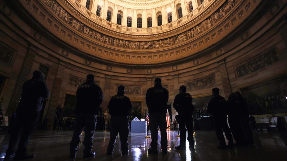 Capitol Police Officers pay their respects to late US Capitol Police officer Brian Sicknick as he lies in honor in the US Capitol Rotunda in Washington, February 2, 2021. US President Joe Biden paid his respects Tuesday at a solemn memorial to the policeman killed last month during an attack on the Capitol by Donald Trump's supporters.  LEAH MILLIS / POOL / AFP