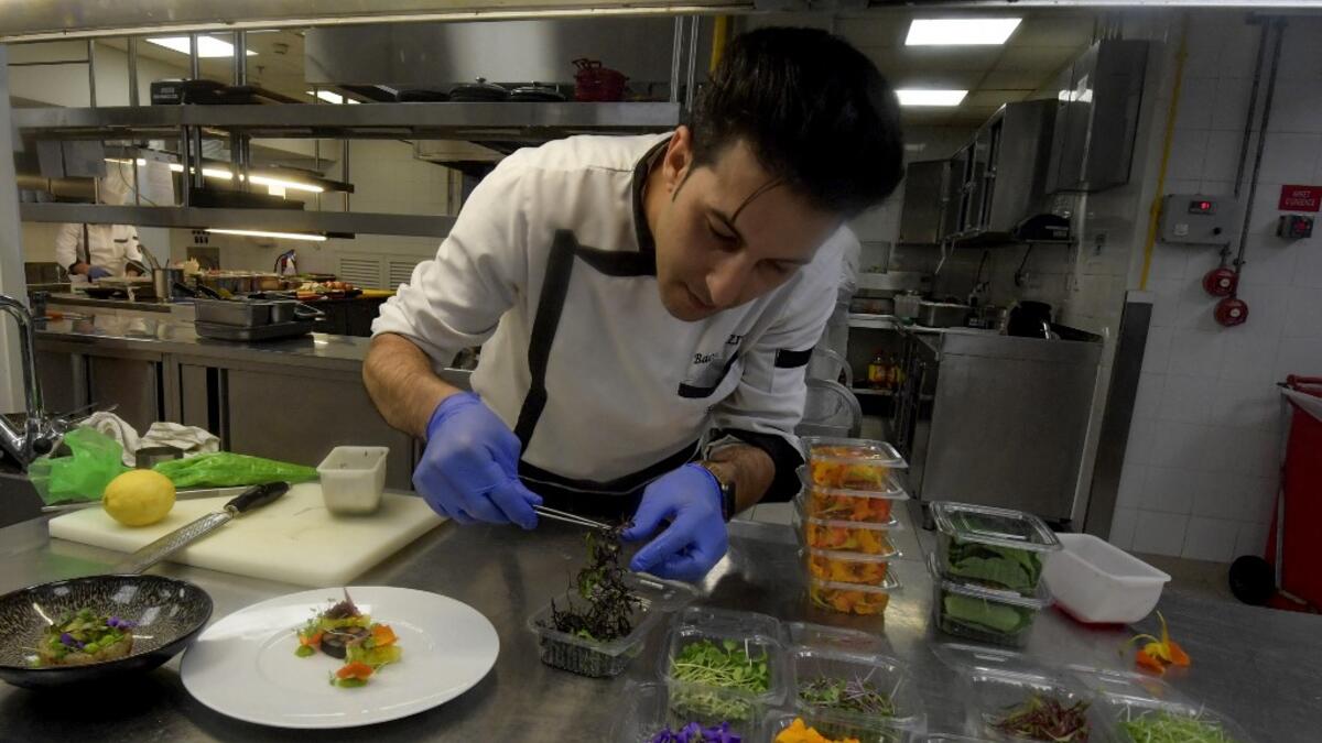 Tunisian chef Bassem Bizid uses edible flowers to prepare his dishes at a luxury hotel in Gammarth, an upscale northern suburb of the capital Tunis, on February 5, 2021. FETHI BELAID / AFP