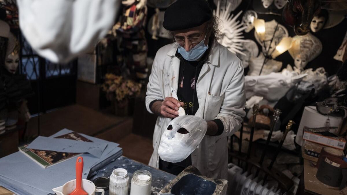 Mask artisan Hamid Seddighi works on a papier-mache mask in his laboratory 'Ca del Sol' in Venice on February 6, 2021, as the traditional Venice carnival is being cancelled due to the Covid-19 pandemic. Marco Bertorello / AFP