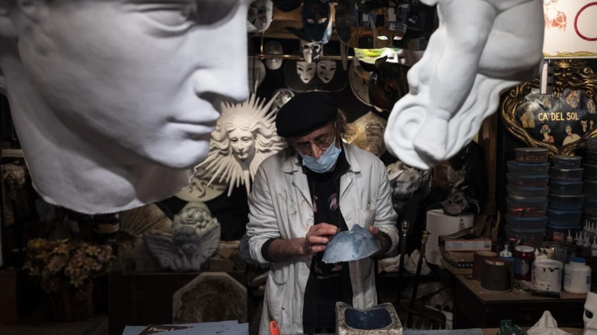 Mask artisan Hamid Seddighi works on a papier-mache mask in his laboratory 'Ca del Sol' in Venice on February 6, 2021, as the traditional Venice carnival is being cancelled due to the Covid-19 pandemic. Marco Bertorello / AFP