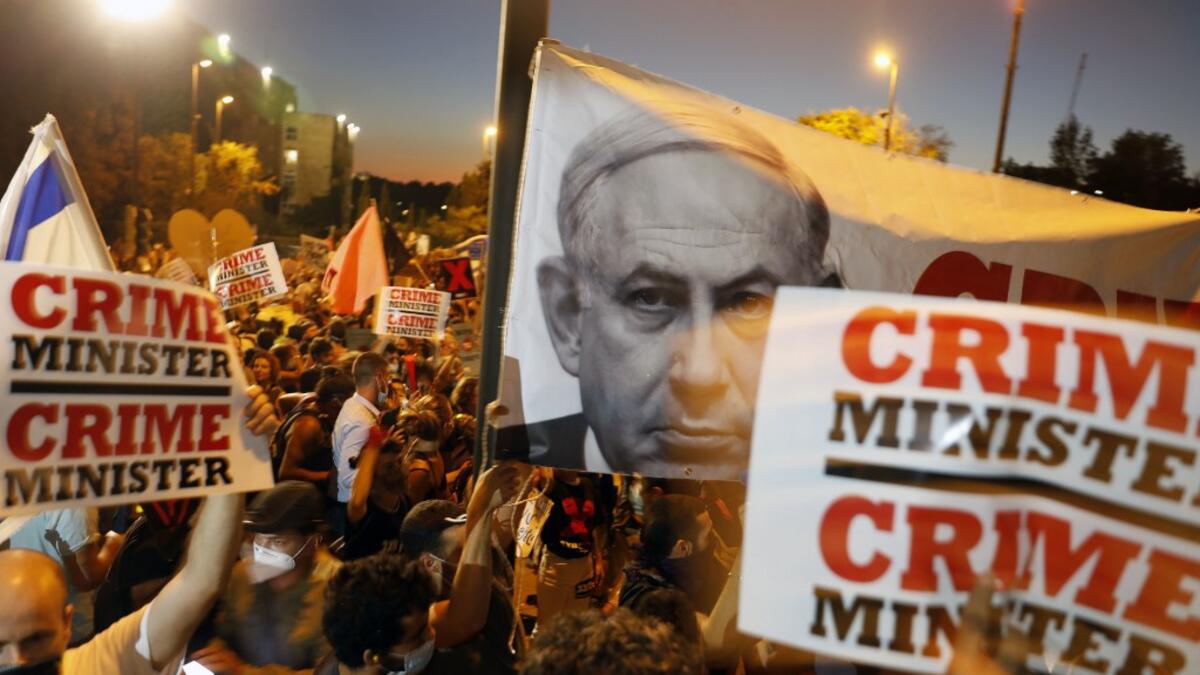 In this file photo taken on July 21, 2020, Israelis protest against Israeli Prime Minister Benjamin Netanyahu in Jerusalem. Israel's Prime Minister Benjamin Netanyahu returns to court on February 8, 2021 to formally respond to the corruption charges filed against him, as his trial enters an intensified phase six weeks before he faces re-election. MENAHEM KAHANA / AFP