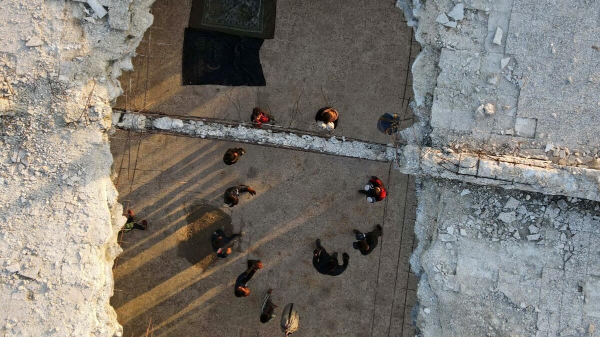 Syrian youths take part in a boxing workout held by local boxer Ahmad Dwara (unseen) inside a damaged building in the town of Atareb in the rebel-held western countryside of Syria's Aleppo province, on February 11, 2021. AAREF WATAD / AFP
