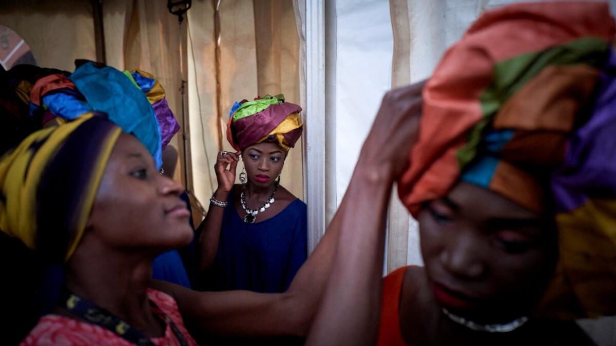 Gold miners are helped to get ready in the backstage prior to take part in a fashion show as part of the first edition of the International Gold Fair Afrik'Or, in Bamako, on February 12, 2021. The Princess of Burundi Esther Kamatari, selected 34 women among gold mines workers in southern Mali, to walk down the catwalk for a fashion show organised during the International Gold Fair. Gold represents 15% of Mali's exports and more than 20% of its GDP estimated at nearly US$20 billion by the end of 2019. MICHEL