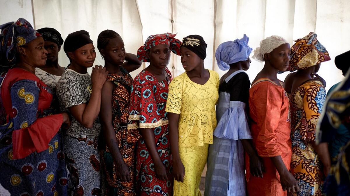 A group of gold miners queue in the backstage after having been selected by the Princess of Burundi, Esther Kamatari, to take part in a fashion show as part of the first edition of the International Gold Fair Afrik'Or, in Bamako, on February 12, 2021. The Princess of Burundi, selected 34 women among gold mines workers in southern Mali, to walk down the catwalk for a fashion show organised during the International Gold Fair. Gold represents 15% of Mali's exports and more than 20% of its GDP estimated at near