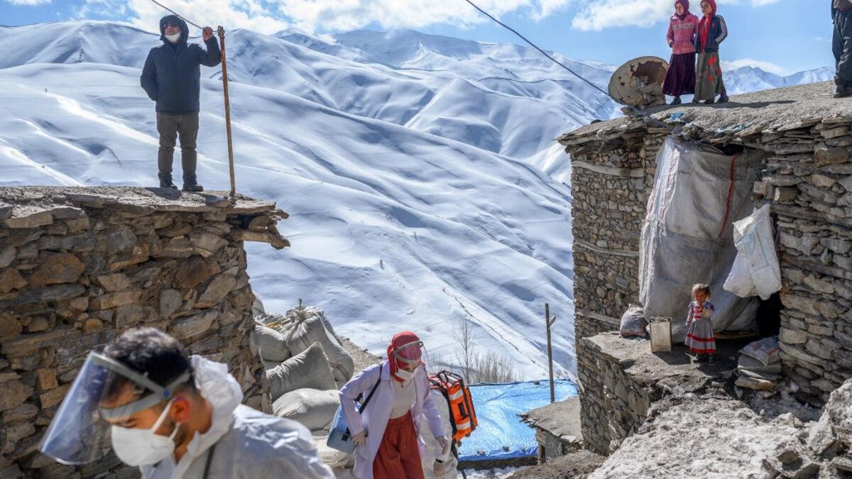 In this photograph taken on February 15, 2021, doctor Sergen Saracoglu (L) and nurse Yilzdiz Ayten (C) from the Bahcesaray public hospital vaccination team, arrive at the village of Guneyyamac in eastern Turkey, as part of an expedition to vaccinate residents of 65 years old or above with Sinovac's CoronaVac Covid-19 vaccine. Turkey's population of more than 83 million is spread out across Europe and Asia and covers some seemingly impregnable terrain. The vaccination effort with China's CoronaVac jab kicked