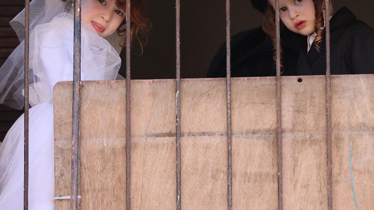 Israeli children dressed in costumes in celebration of the Jewish holiday of Purim are pictured in the ultra-Orthodox neighborhood of Bnei Brak, on February 26, 2021. Israel imposed a night-time curfew for three nights from yesterday evening to curb the spread of the coronavirus during the Jewish holiday of Purim, the government said. The curfew, from 8:30 pm to 5:00 am daily (1830 GMT to 0300 GMT), will be in force from Thursday night until Sunday morning, a joint statement from the prime minister's office