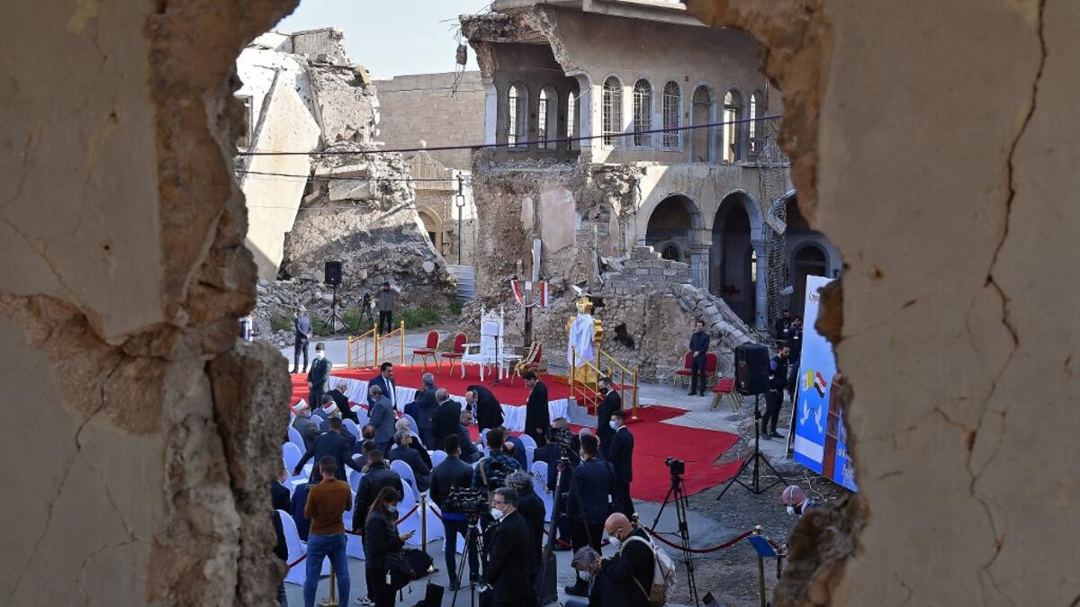 Iraqis gather near the ruins of the Syriac Catholic Church