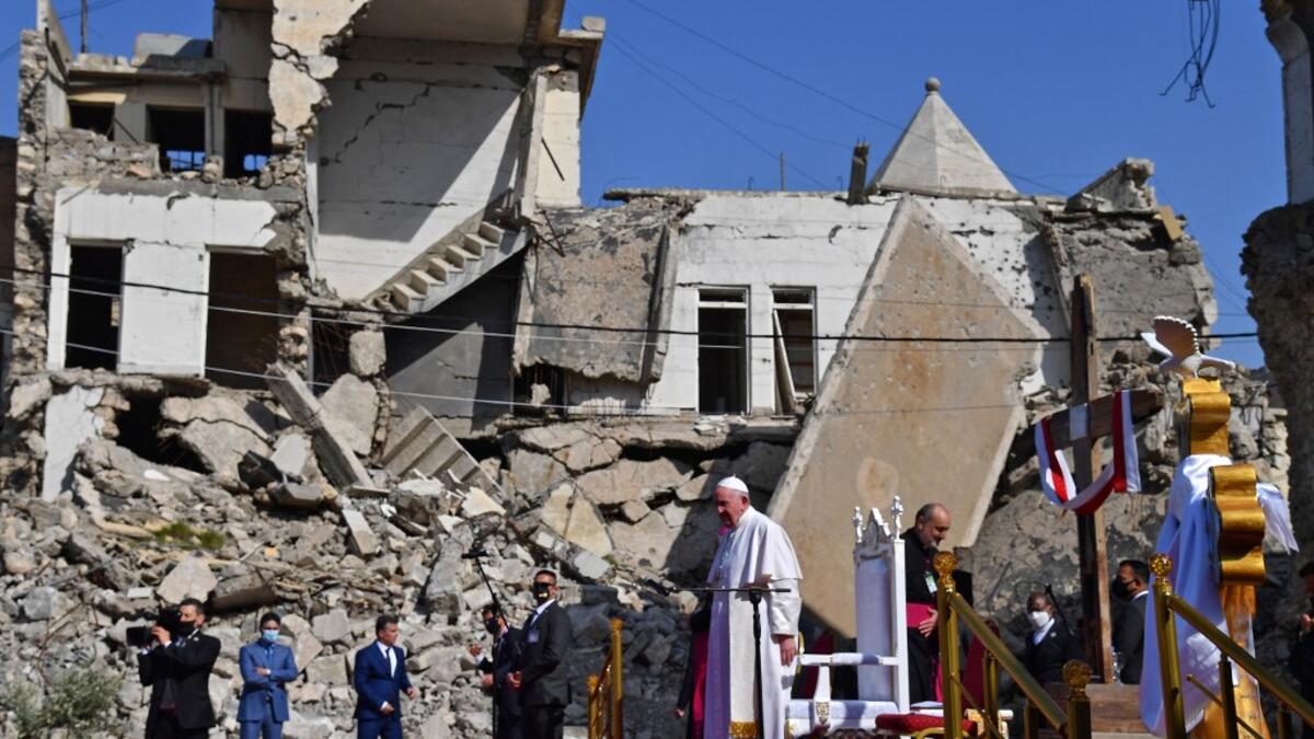 Pope Francis (C) arrives at the ruins of the Syriac Catholic Church of the Immaculate Conception