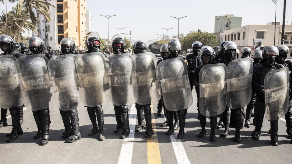 Police officers take their positions during a protest in Dakar on March 8, 2021, after the country's opposition leader Ousmane Sonko was charged with rape. Usually considered a beacon of stability in a volatile region, deadly clashes between opposition supporters and security forces have rocked the West African state. JOHN WESSELS / AFP