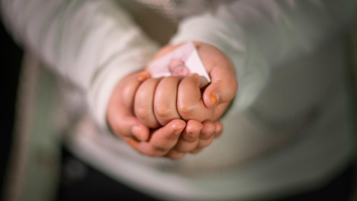 Sham, 7 years, in Za’atari Refugee Camp holding a photo of her father.