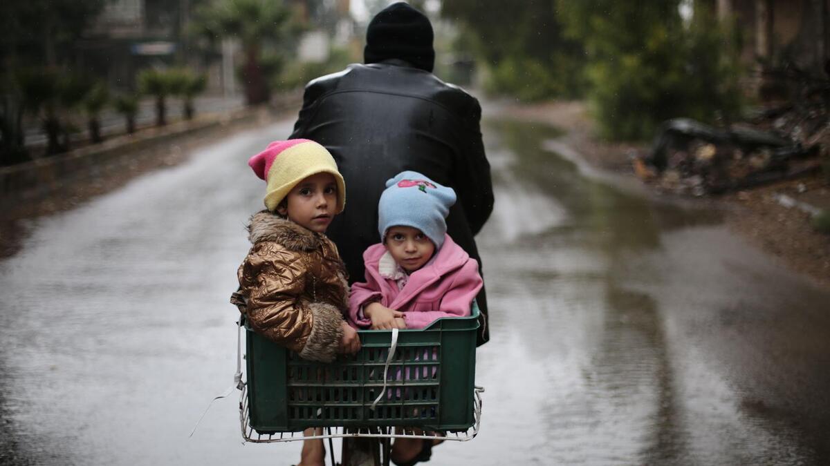 On 9 October in East Ghouta, children ride on the back of a bicycle.