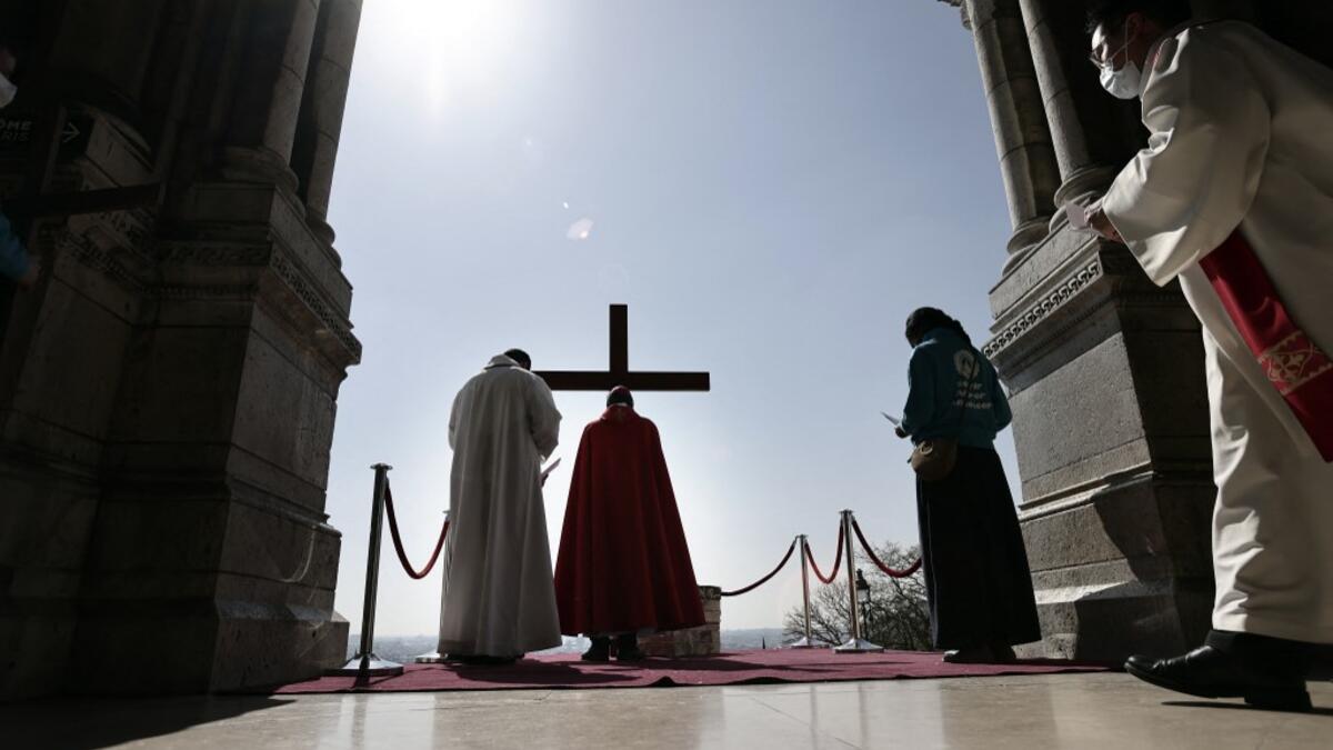 Archbishop of Paris Michel Aupetit carries the holy cross at the Way of the Cross ceremony during the Good Friday as part of the Holy Week