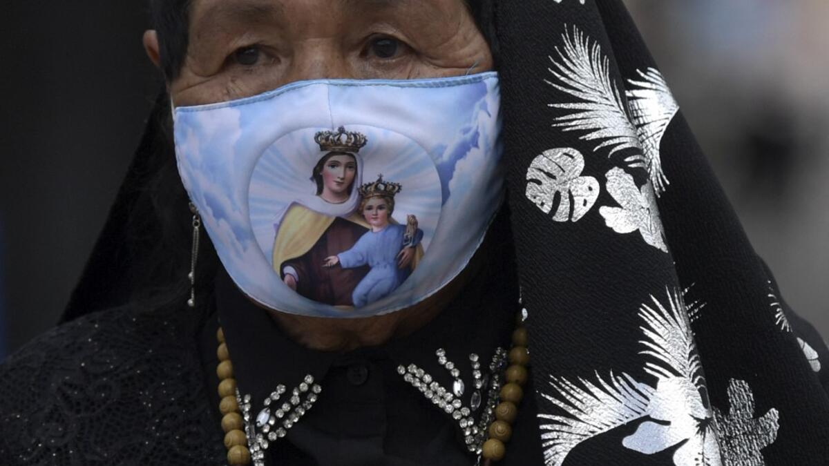 A Catholic devotee wearing a face mask as a precautionary measure against the spread of the novel coronavirus disease
