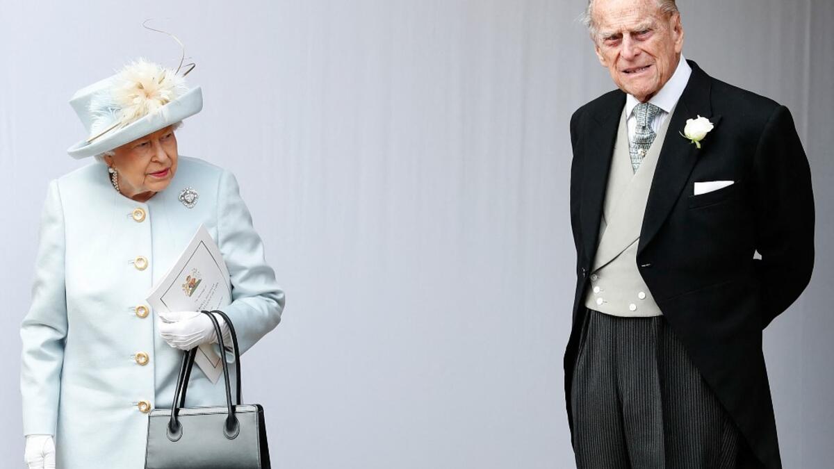 October 12, 2018 Britain's Queen Elizabeth II (L) and Britain's Prince Philip, Duke of Edinburgh (R) wait for the carriage carrying Princess Eugenie of York and her husband Jack Brooksbank