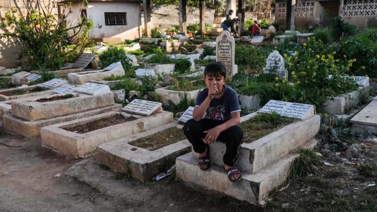 A boy sits on a grave in the Ghoraba (Strangers) cemetery