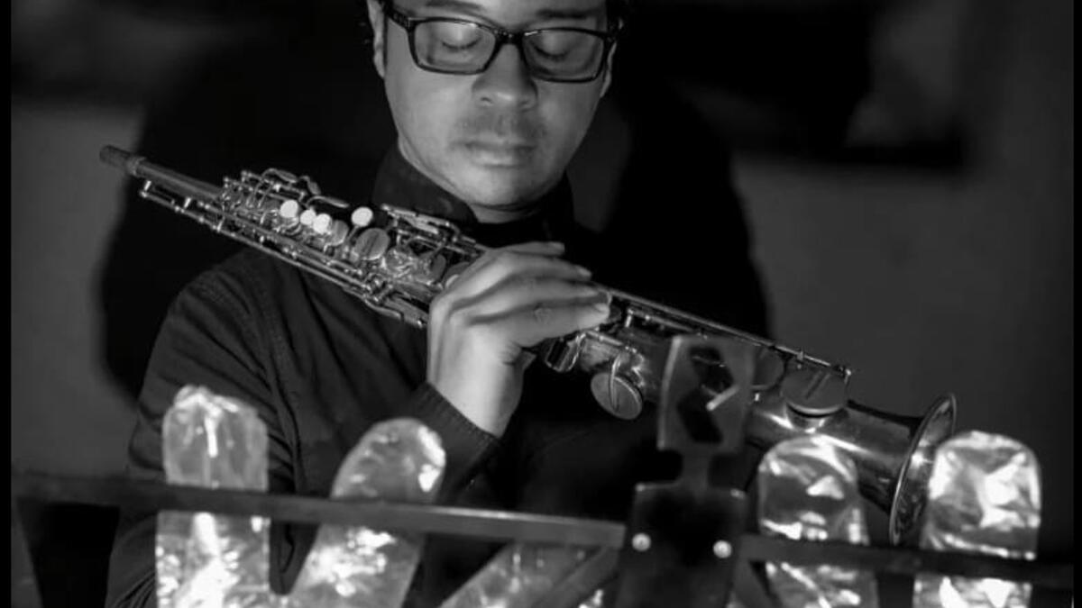 A musician in foil gloves is playing an instrument