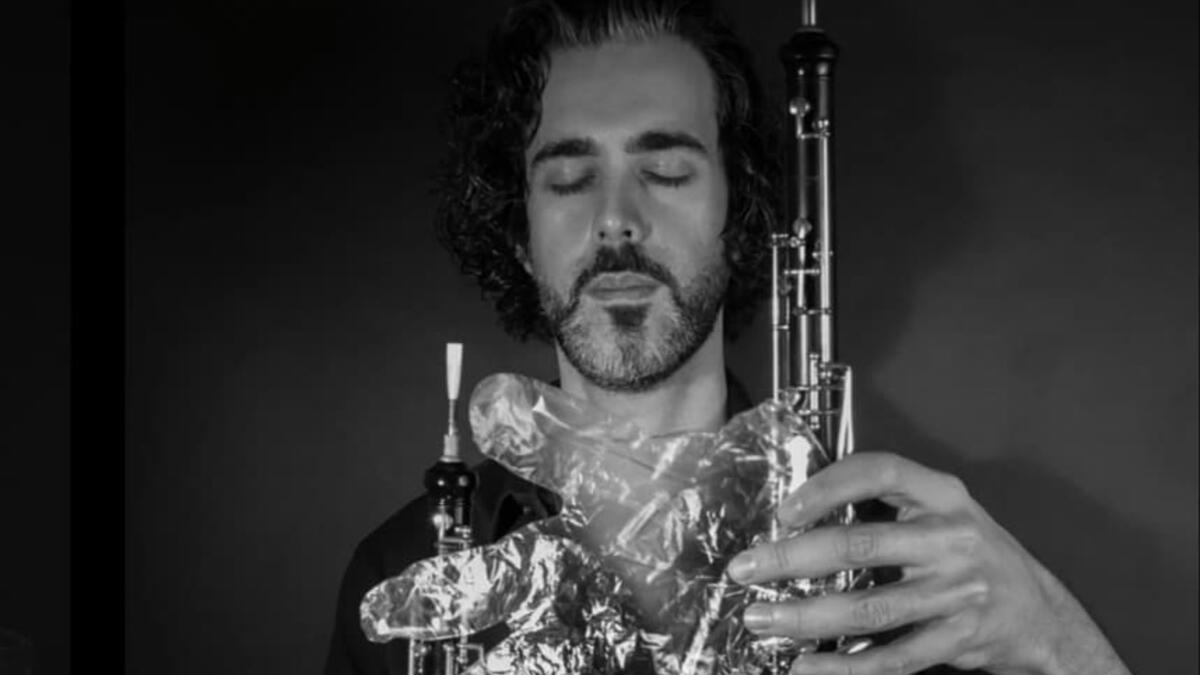 A musician in foil gloves is playing an instrument