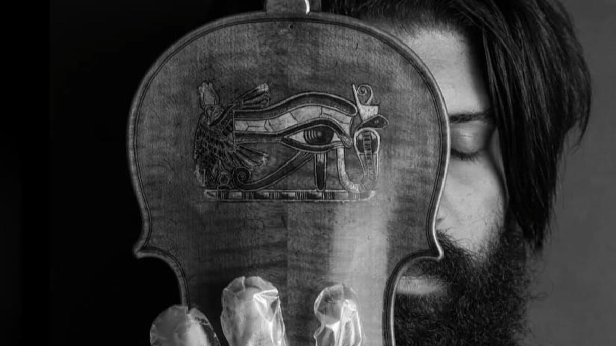 A musician in foil gloves is playing an instrument