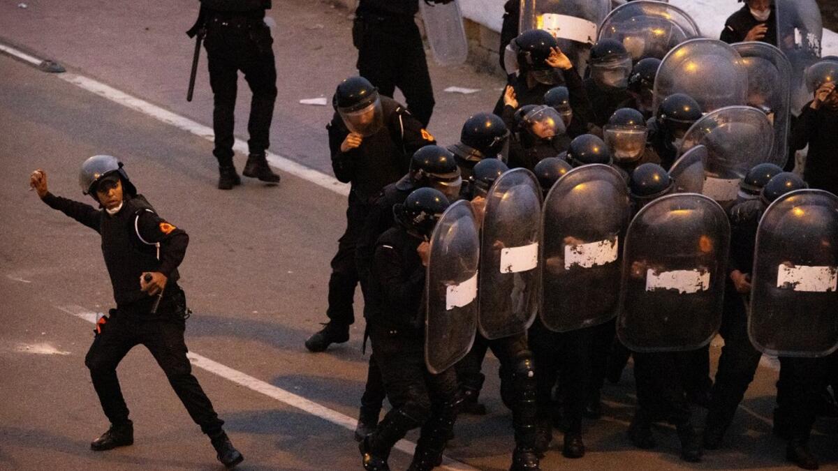 A Moroccan riot police throws a rock back at migrants during light clashes in the northern town of Fnideq, close to the border between Morocco and Spain's North African enclave of Ceuta on May 19, 2021. Migrants were still trying to cross from Morocco into the Spanish enclave of Ceuta on May 19, 2021, after a record 8,000 people poured over the border this week, escalating tensions between Rabat and Madrid. Some 5,600 migrants had already been sent back