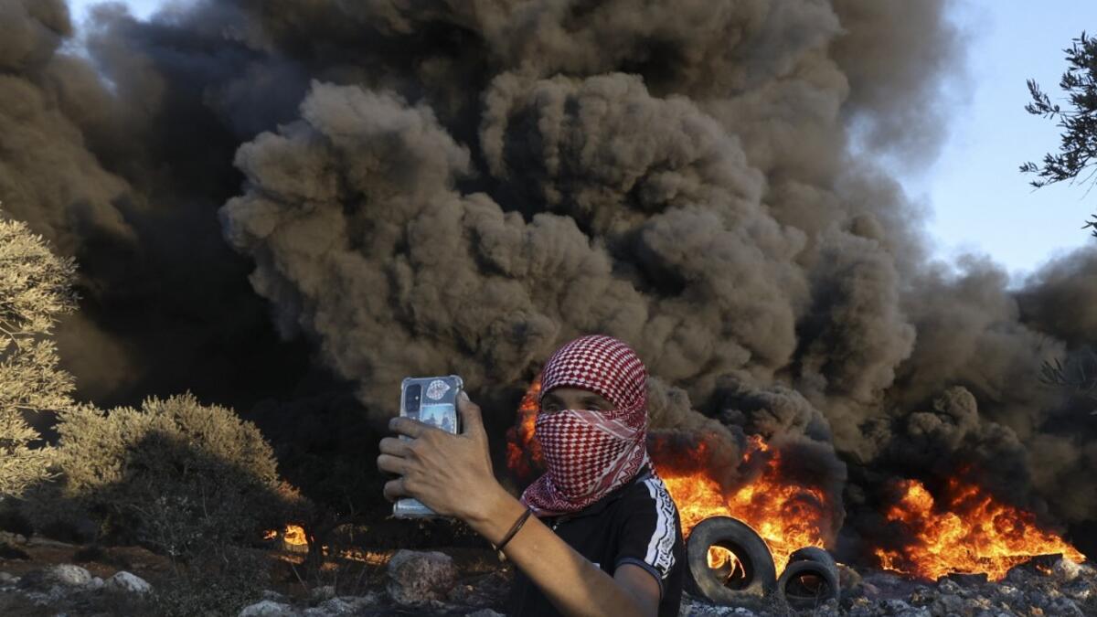 Palestinians burn tires during a night demonstration against the expansion of the Jewish settlement outpost of Eviatar on the lands of Beita village, near the occupied West Bank city of Nablus