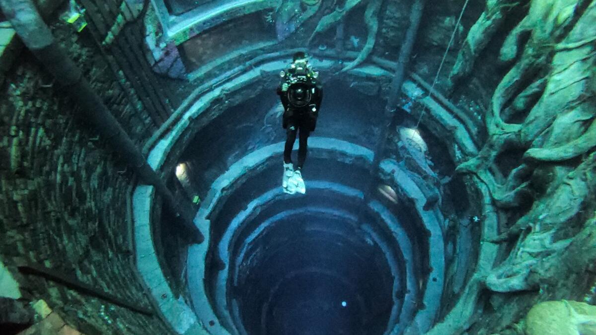 A diver experiences Deep Dive Dubai, the deepest swimming pool in the world reaching 60m, in the United Arab Emirates, on July 10, 2021. The city of superlatives, with the world's tallest tower among its many records, Dubai now has the deepest swimming pool on the planet complete with a "sunken city" for divers to explore. GIUSEPPE CACACE / AFP