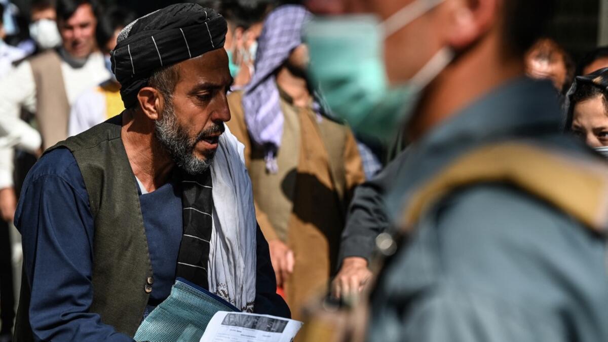 A man arrives to submit his passport application at an office in Kabul on July 25, 2021. Dozens begin lining up at the passport office in Kabul before dawn most days, and by eight in the morning the queue already stretches for a good hundred metres.