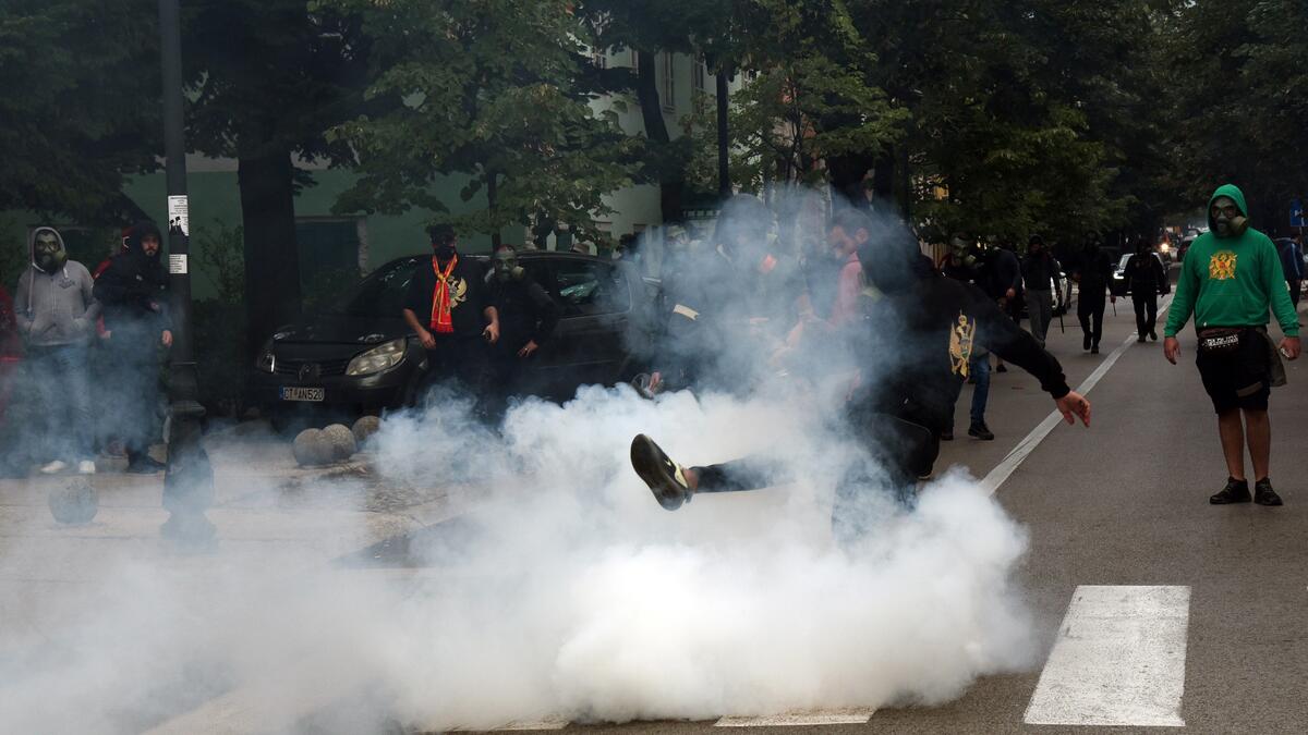 A demonstrator kicks back a tear gas canister during clashes following a protest against the inauguration of the new head of the Serbian Orthodox Church on September 5, 2021 in the historic city of Cetinje in Montenegro.