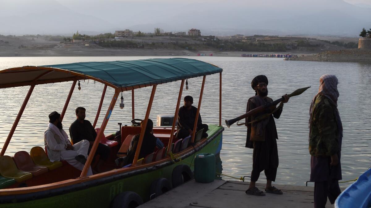 Taliban fighter shouts on the pirate ship ride at a fairground in western Kabul, as his armed comrades cackle and whoop on board the rickety attraction. (Photo by WAKIL KOHSAR / AFP) / TO GO WITH: AFGHANISTAN-CONFLICT-FAIRGROUND, SCENE BY JAMES EDGAR - TO GO WITH: Afghanistan-conflict-fairground, SCENE by James EDGAR