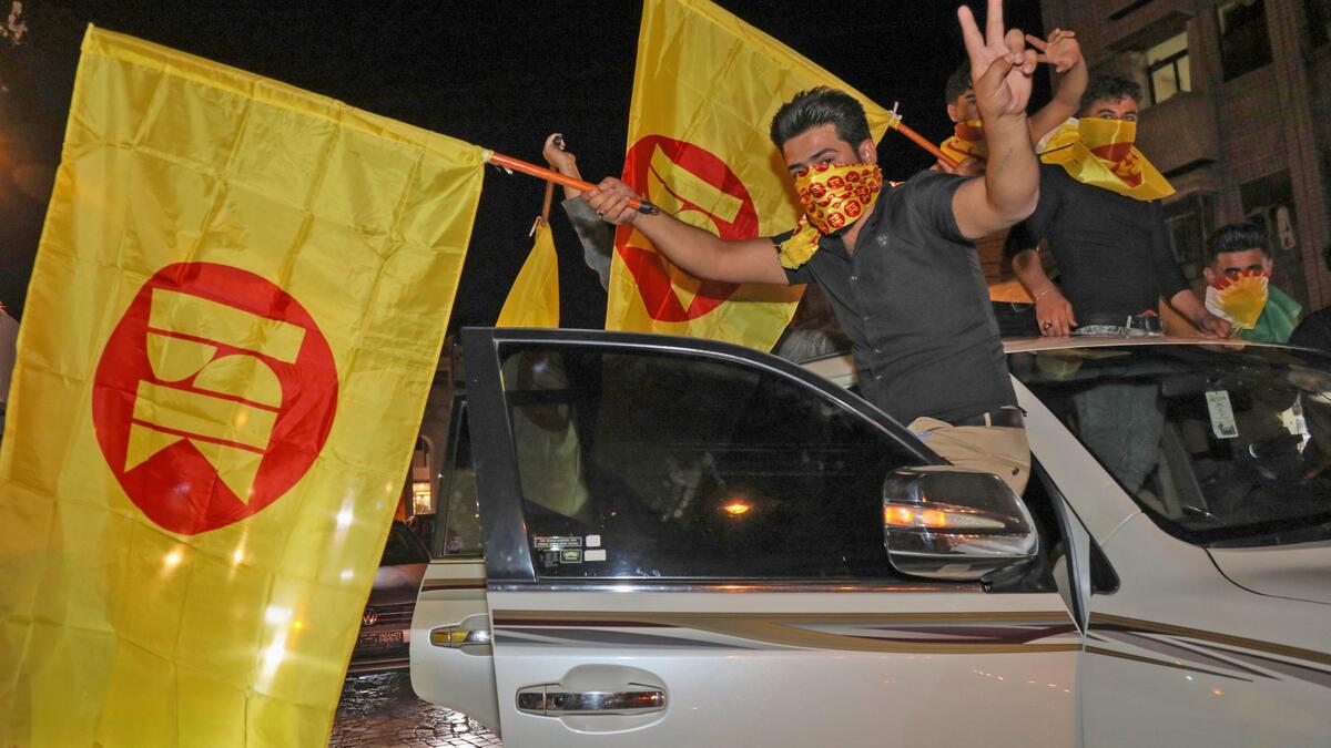 Supporters of the Kurdistan Democratic Party (KDP) celebrate with the KDP party flags during Iraq's parliamentary election in Arbil, the capital of the northern Iraqi Kurdish autonomous region, on October 10, 2021. Preliminary turnout figures showed many citizens boycotted Iraq's parliamentary election, held a year early to appease protestors, in an oil-rich country riddled by corruption and beholden to armed factions. (Photo by SAFIN HAMED / AFP)