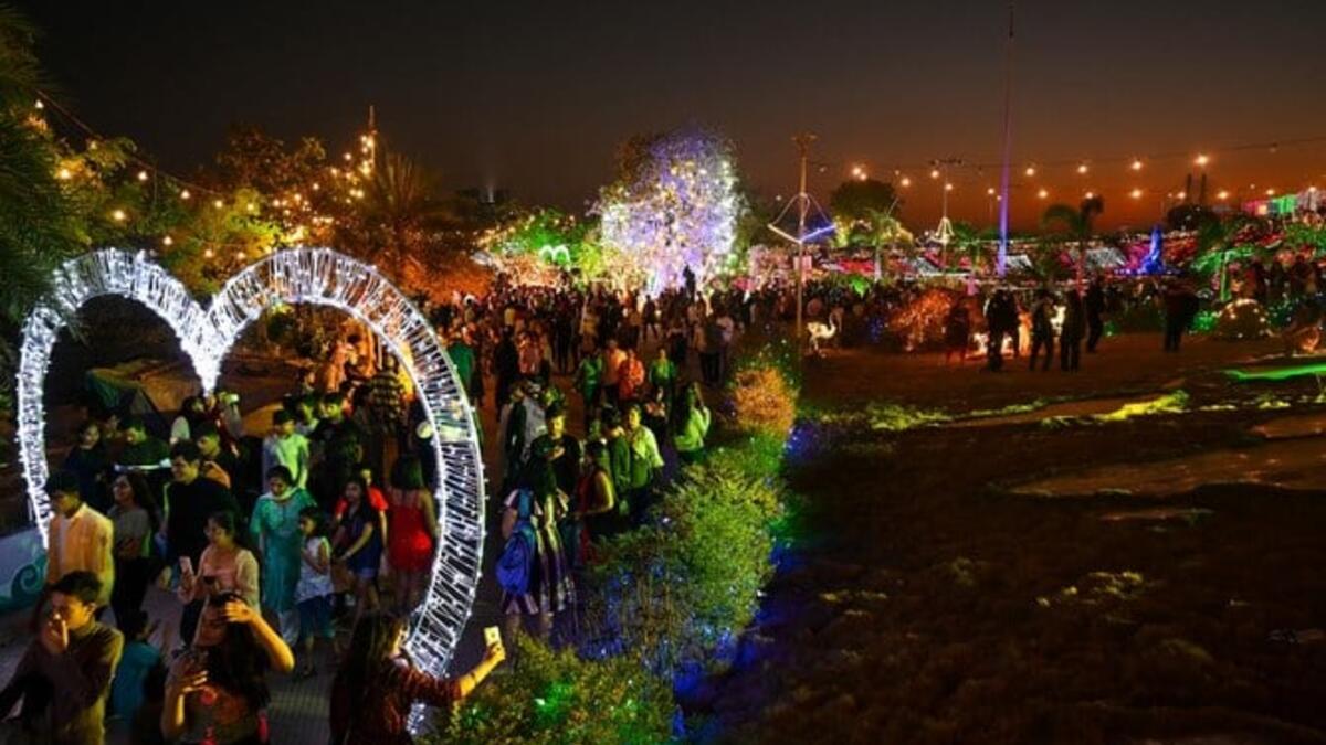 الناس يتجمعون على كورنيش البحر أثناء غروب الشمس ليلة رأس السنة الجديدة في مومباي في 31 ديسمبر 2022.  (أ ف ب)