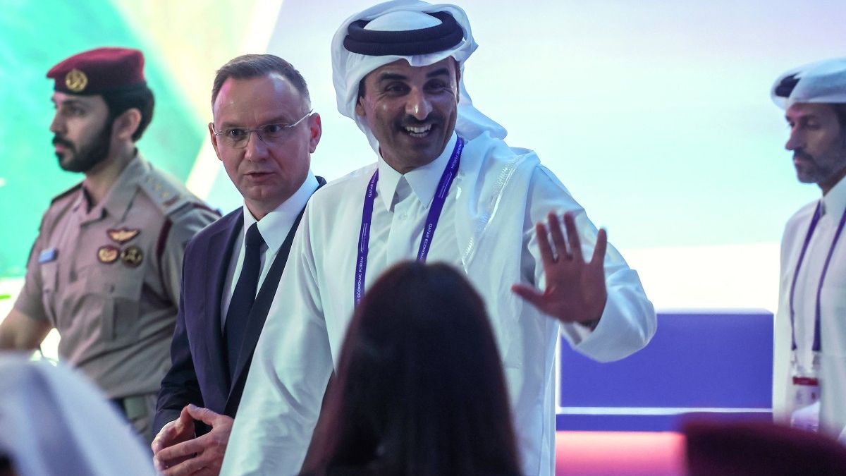 Qatar's Emir, Sheikh Tamim bin Hamad Al-Thani (R) waves as he walks alongside Poland's President Andrzej Duda (C) at the Qatar Economic Forum in Doha on May 14, 2024. (Photo by KARIM JAAFAR / AFP)